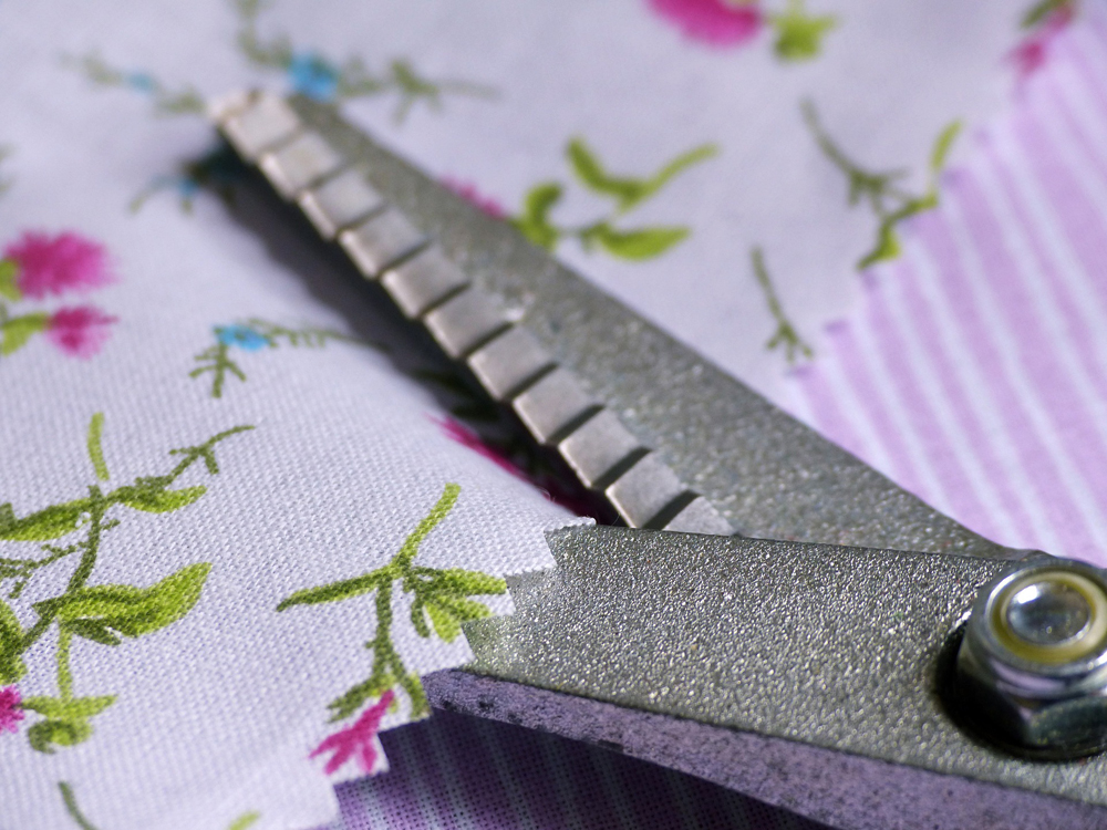 Scissors cutting fabric with flower print